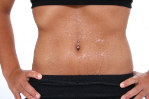 Teen girl's abdomen with belly ring covered in sweat. Shot with the Canon 20D.