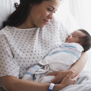 mother-in-hospital-bed-holding-newborn-baby-girl-1-730x400